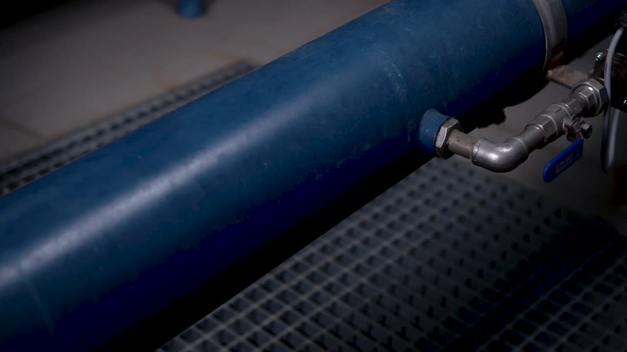 A large blue pipe runs inside the basement of the waterworks