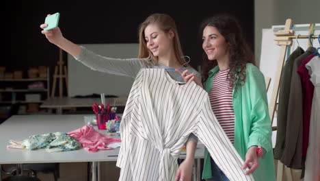 customer taking selfie in tailor studio with dressmaker.