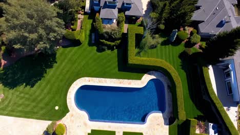 aerial view of a luxurious home and garden with swimming pool