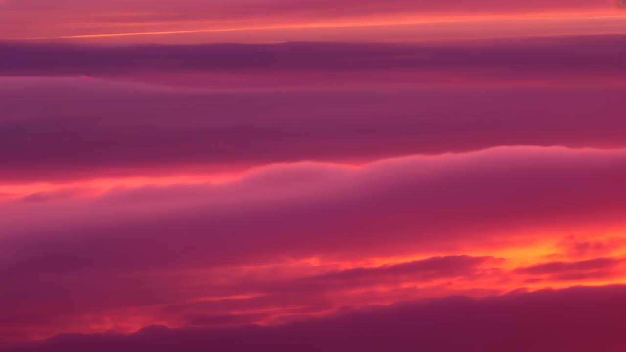Sun descending over stratocumulus cloud layer at sunset, revealing deepening horizon light band