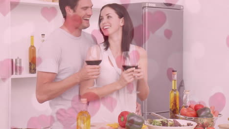 couple preparing dinner while drinking red wine