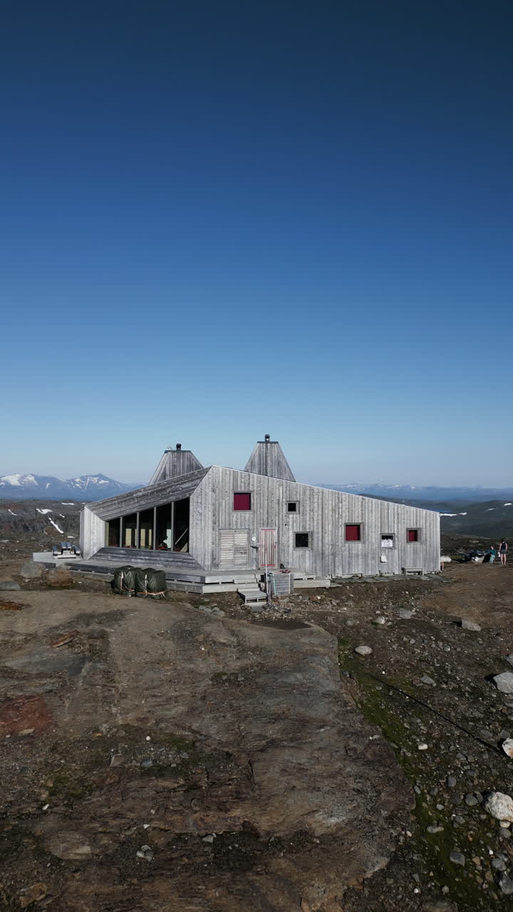 Vertical aerial shot of Rabothytta cabin, situated on the edge of Okstindbreen glacier, with views of the Okstindan mountain range and highest peak Oksskolten. Korgen, Norway