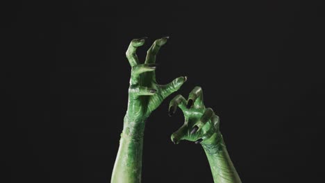 video of halloween green monster hands with copy space on black background