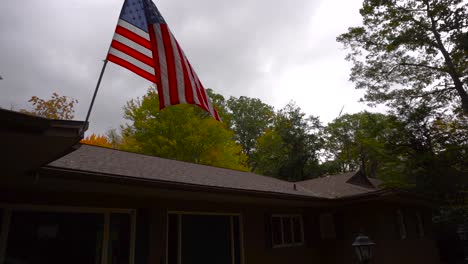 disparo de una bandera estadounidense que sopla en el viento de una tormenta de otoño en michigan, ee.uu.