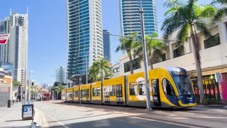 yellow tram moves through urban street scene