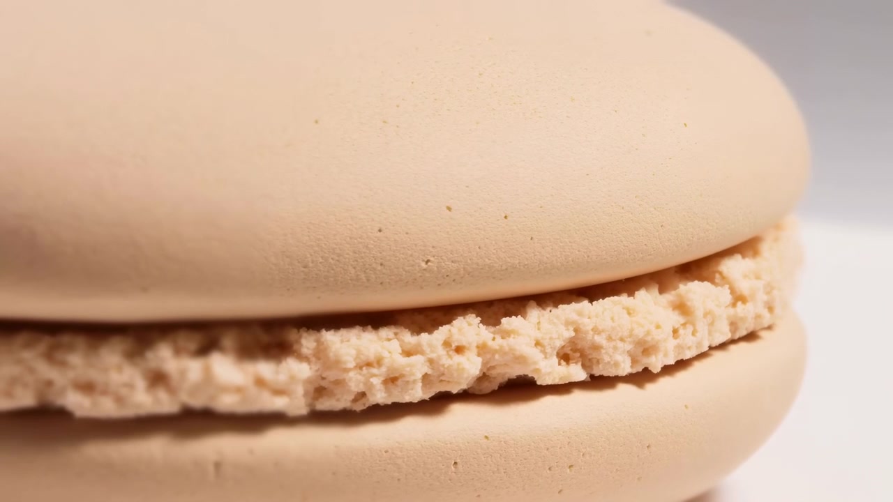 Macaron static, in neutral background, with macarons, from a close-up perspective, with beige, brown accents, and neutral mood, showing nearby objects and surrounding setting, nearby objects.