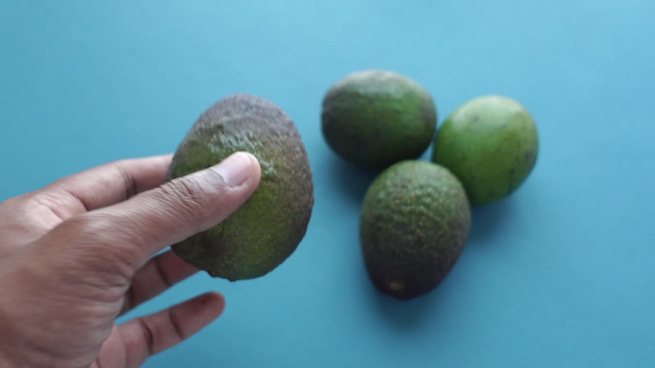 Mão Alcançando Abacates