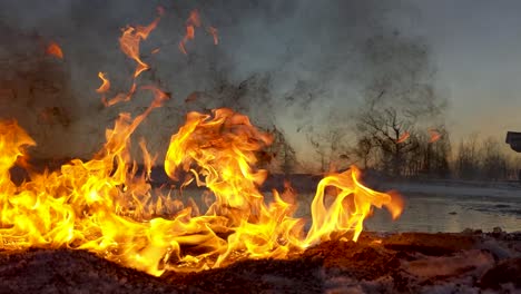 el derrame de petróleo en llamas envía humo negro sucio al cielo mientras el sol sale en el fondo