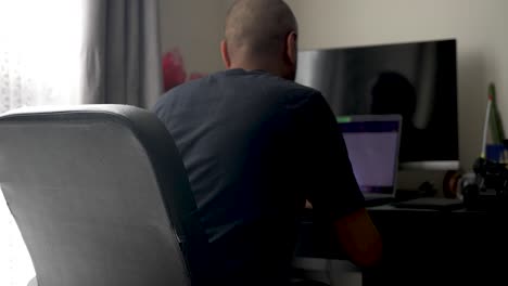 Man working on laptop at home office desk