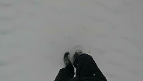 straight down view of feet walking in freshly fallen snow - point of view