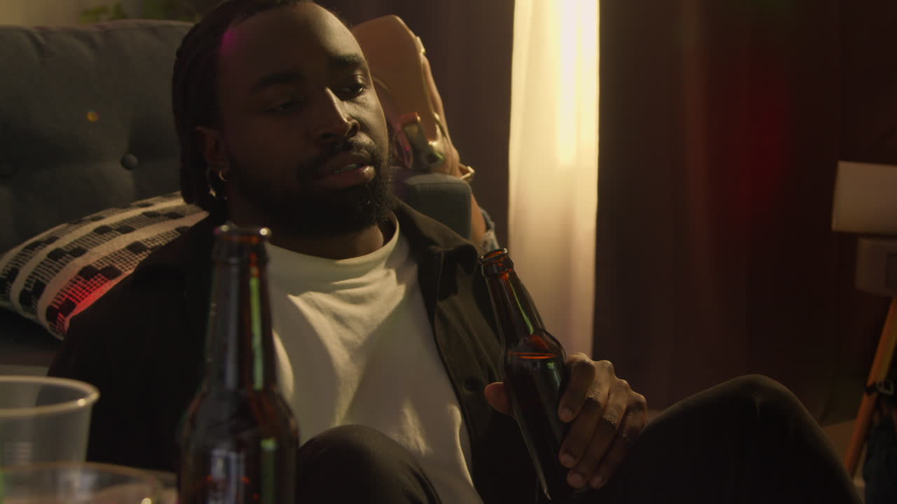 Man Sitting By Sofa At House Party Deciding He Has Had Enough Alcohol To Drink