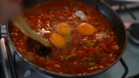 cocinar huevos con tomates y verduras en una sartén
