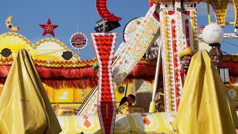 carrusel de alfombras voladoras en el parque de atracciones moviéndose con un niño a bordo