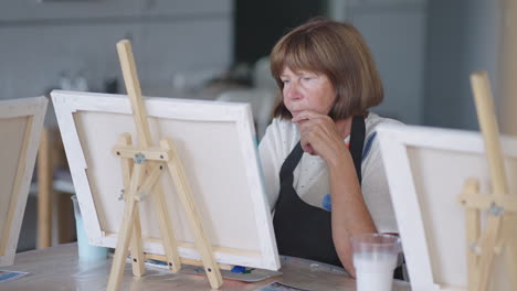 An-elderly-woman-draws-a-picture-in-a-painting-course