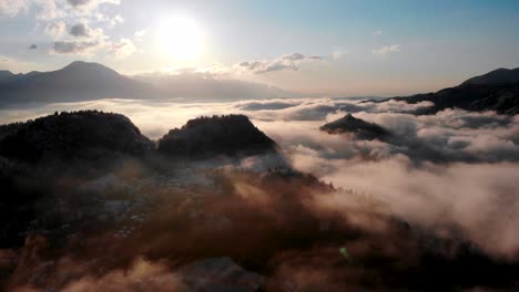 Camera-flying-straight-towards-the-sun-as-the-cloud-inversion-moves-around-under-the-drone