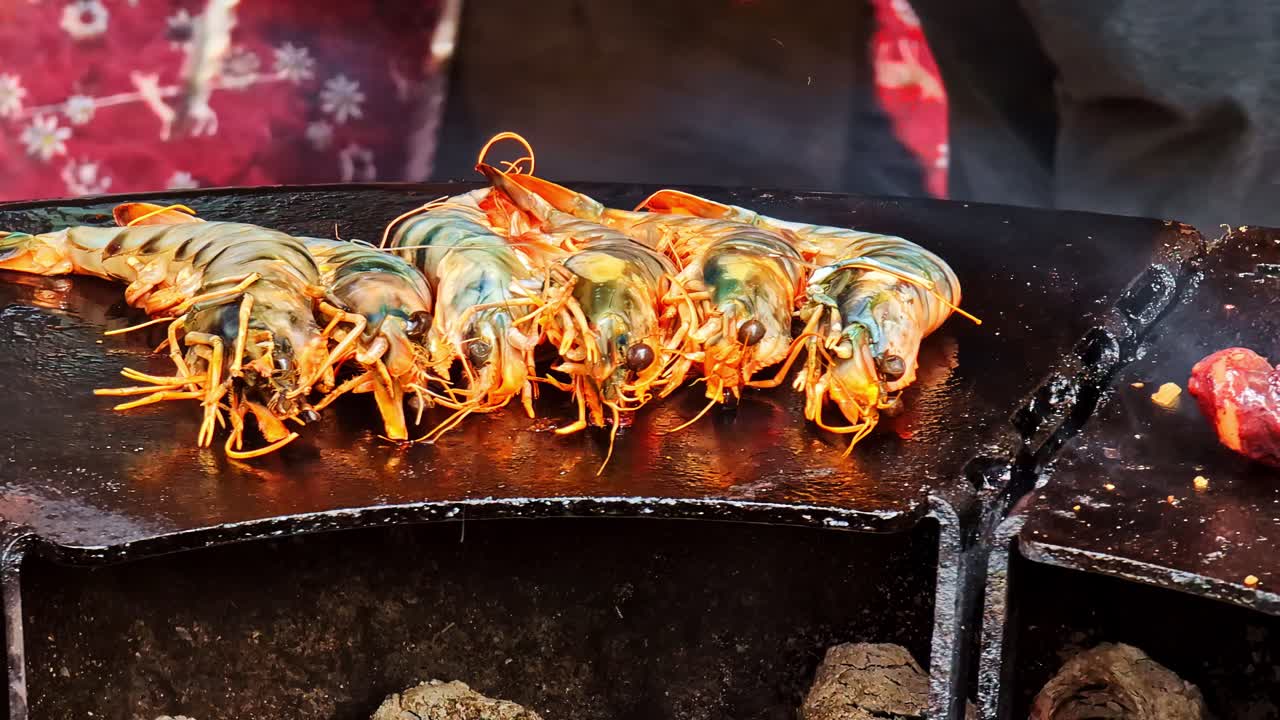Detailed closeup of prawns and octopus tentacles sizzling on smoky charcoal grill