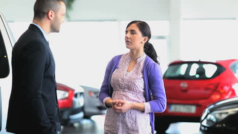 businessman giving car keys while shaking hands