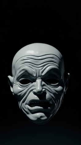 grotesque white mask on black background