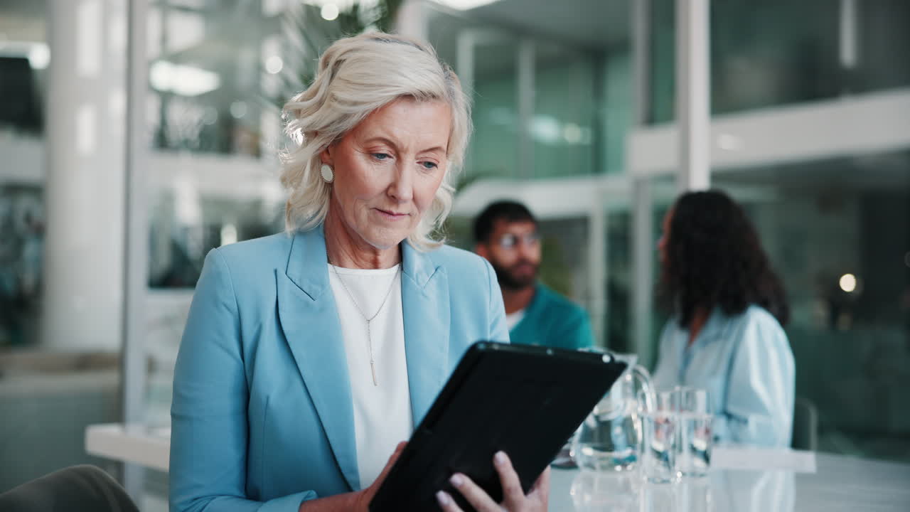 donna d'affari che lavora sul tablet in una riunione in ufficio