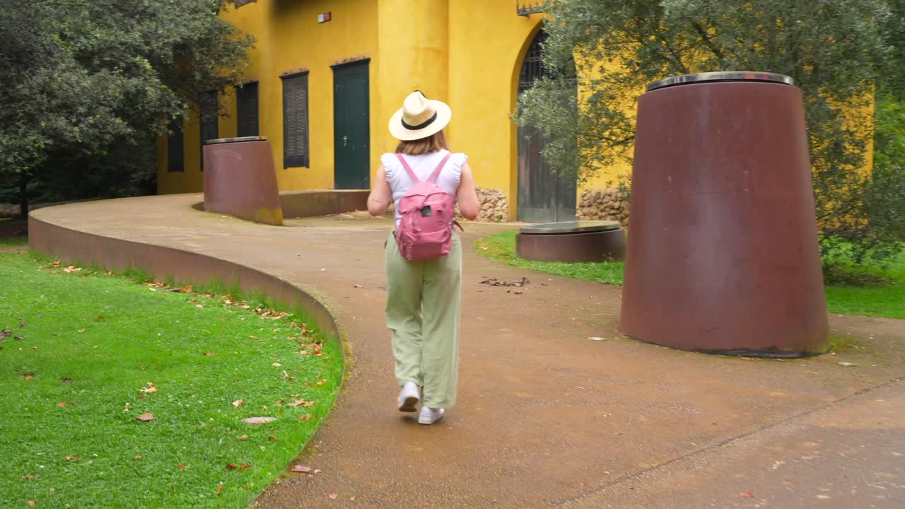 Woman with backpack walking near a yellow building