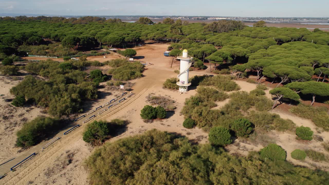 establecimiento de la vista aérea de la torre del faro amarillo de huelva en el sendero del bosque de la playa costera de arena