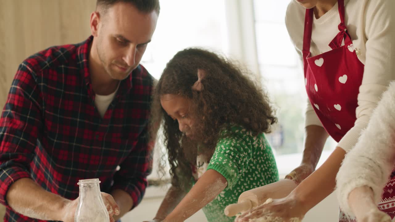 vista de mano de los niños horneando galletas con la ayuda de los padres
