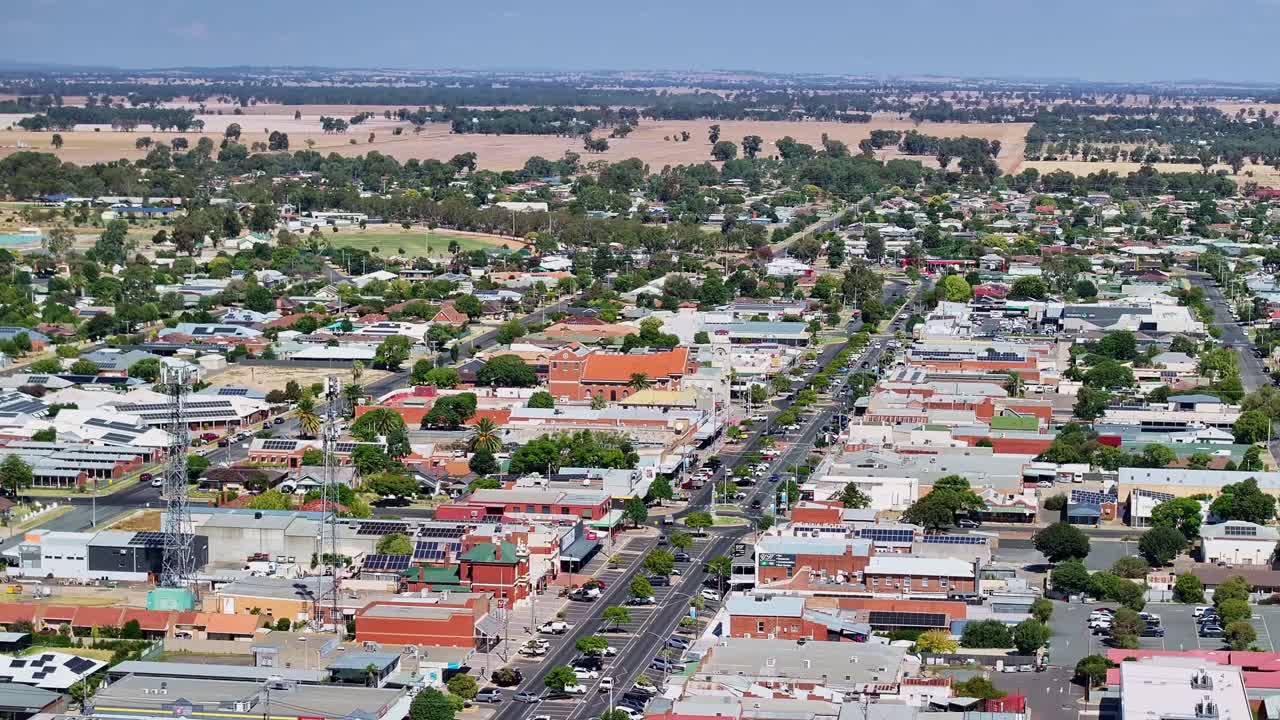 Aerial alongside two telecommunications towers and down the Yarrawonga main street with cars and buildings