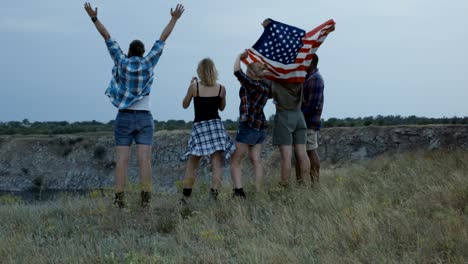 traveling friends with flag on cliff