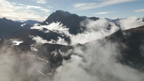 picturesque dolomite mountain peaks with moving clouds, aerial drone view