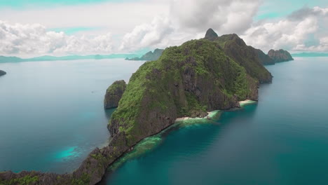 Pull-Up-Aerial-Shot-Of-A-Beautiful-Island-With-Clean-Waters-And-Large-Clouds-In-Palawan