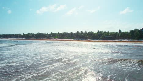 Aerial-View-Flying-Above-Water-In-Bright-Sunny-Mexican-Caribbean-Beachfront