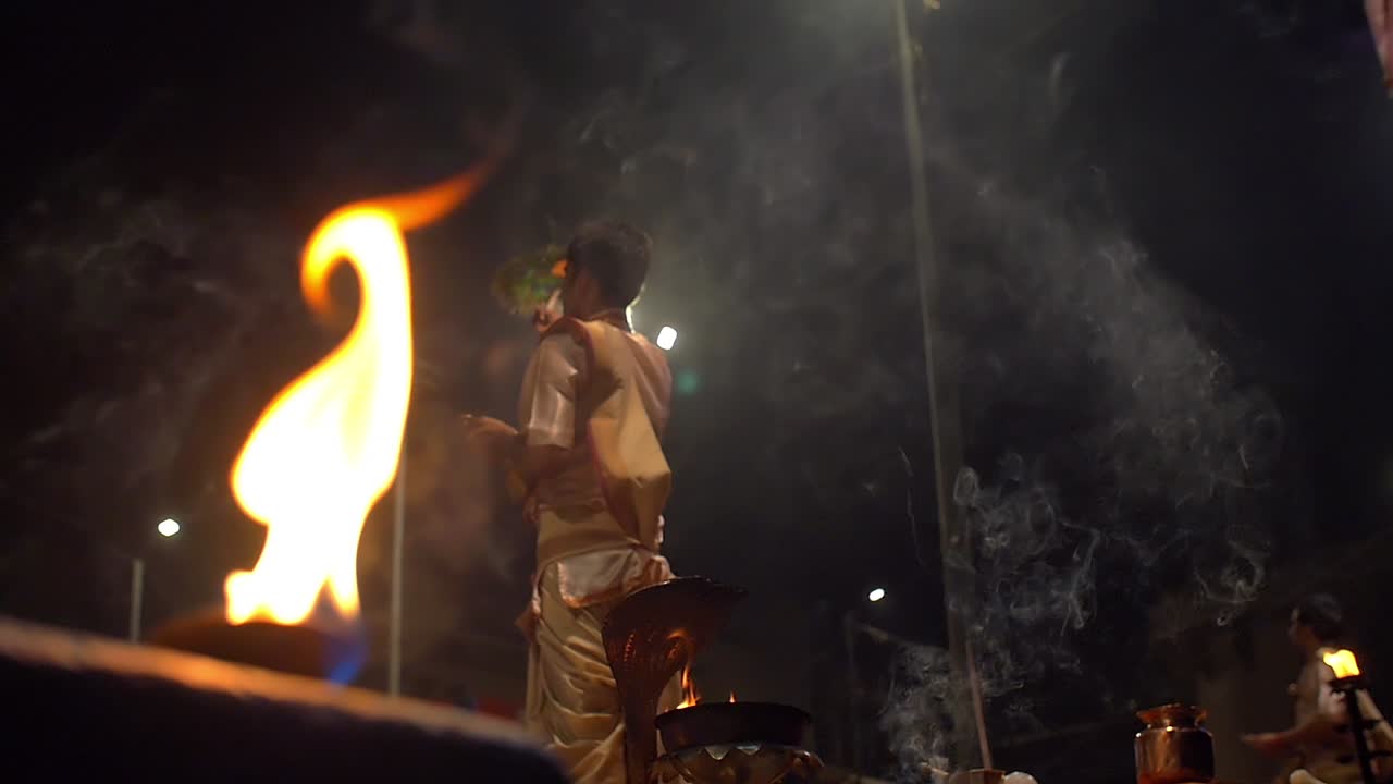 hombres agitando abanicos ceremoniales ganga aarti