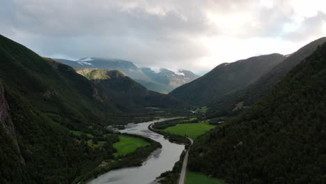 paisaje de cadenas montañosas forestales con río tranquilo durante el día nublado en noruega