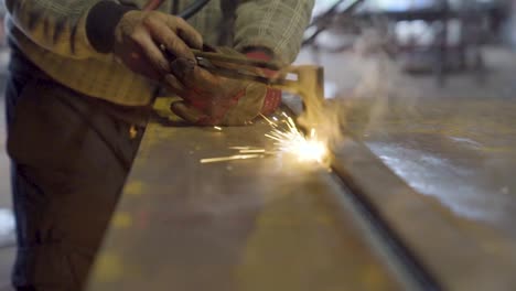 metal worker cutting a thick steel plate with fire torch cutter. bright spark shower