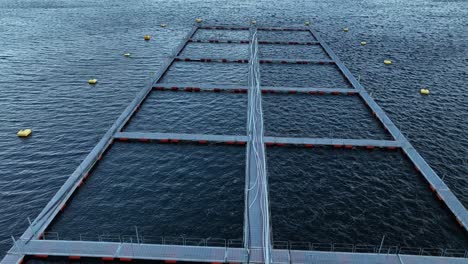 Low-aerial-flying-over-empty-pens-at-fish-farm-in-Western-Norway