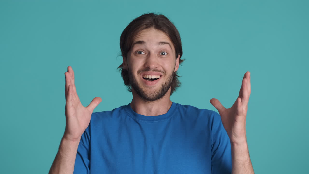 Caucasian happy man in front of camera on blue background.