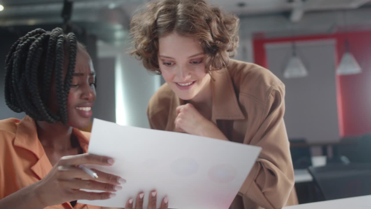 The young african teacher is explaining her student how to do the task that she gave, slow motion close up
