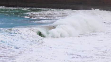 dynamic ocean waves crash against the rocky shoreline at port campbell, australia, under natural daylight, captured in a 15-second sequence