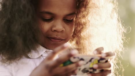 young girl playing with a phone outdoors