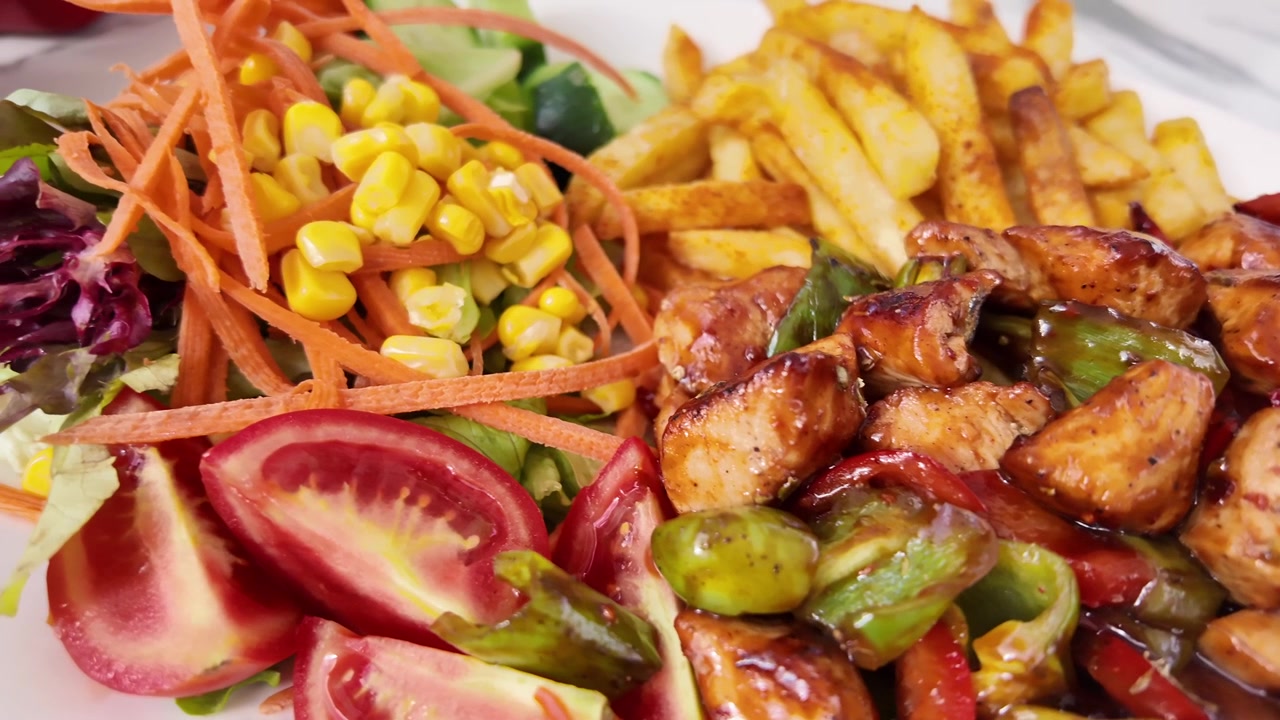 Prato de frango grelhado com legumes e batatas fritas