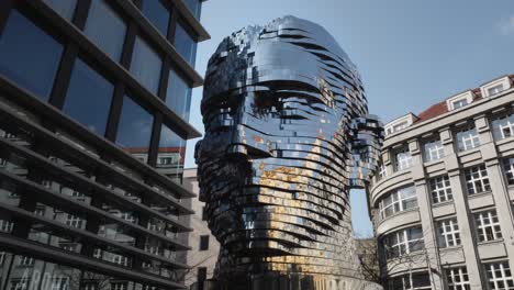 iconic statue of kafka installed outside quadrio shopping centre, prague, czech republic, tilt down shot