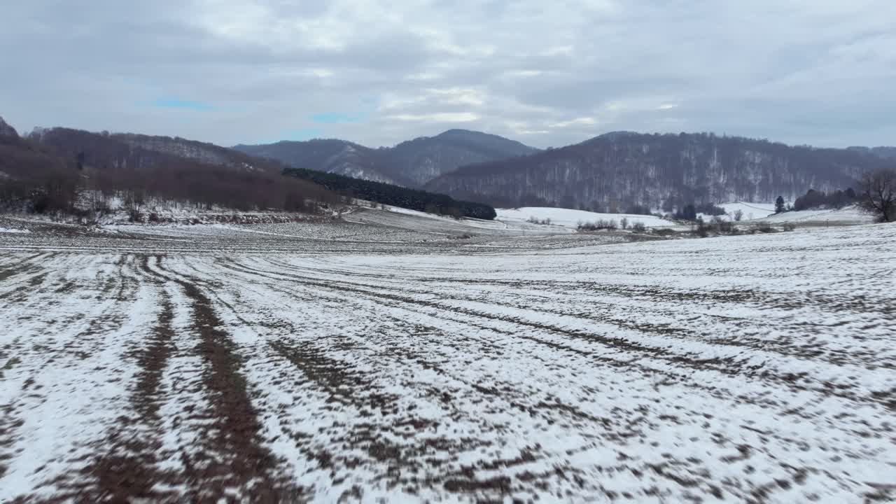 rápido aéreo sobre campos cubiertos de nieve picos de montaña fondo día nublado