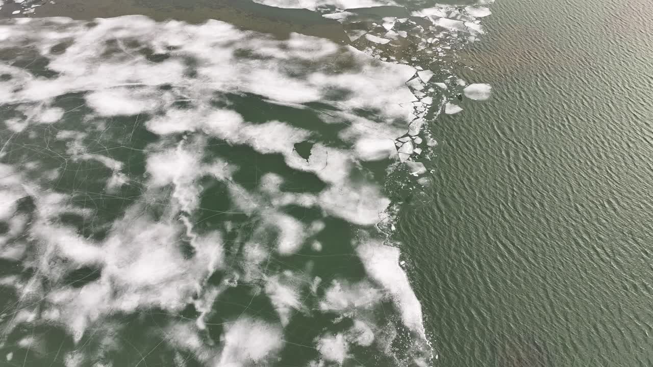 Aerial contrast of cracked ice and unfrozen water surface at Skútustaðir on Lake Mývatn. Reykjahlíð, Iceland