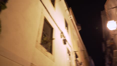 old and typical street with lantern and street nameplate at night