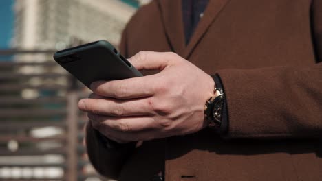 hombre de negocios usando teléfono inteligente al aire libre