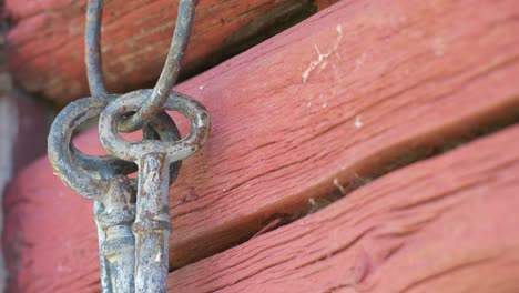 primer plano de llaves antiguas antiguas en la vieja pared roja desgastada, inclinada hacia abajo