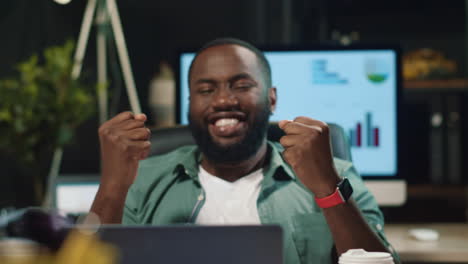 Closeup-happy-american-business-man-celebrating-success-in-hipster-office