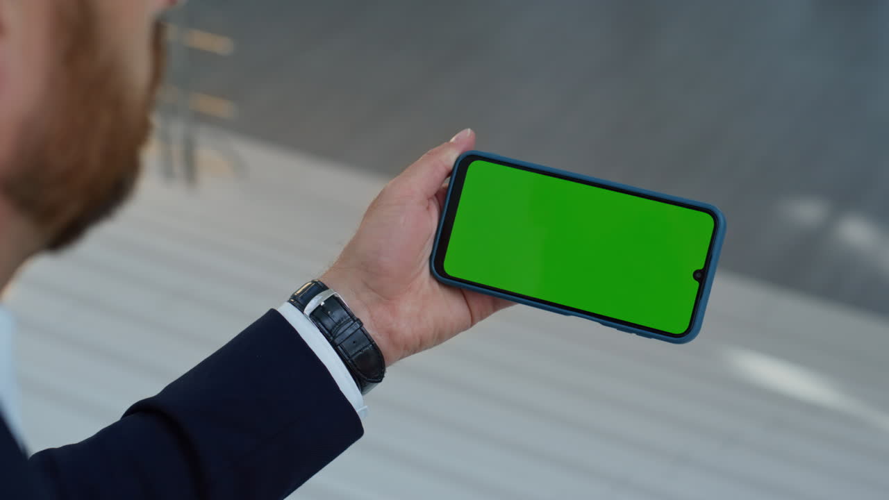 Manager watching video chroma key cellphone sitting office staircase closeup