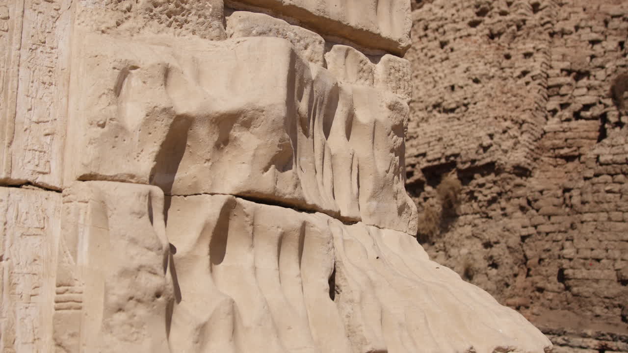 Close-up of a carved stone block at Dendera Temple, showing intricate details of ancient reliefs