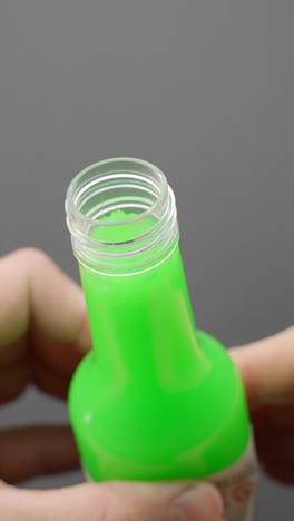 Bright green slime oozing vertically from a container, playful mood, vertical